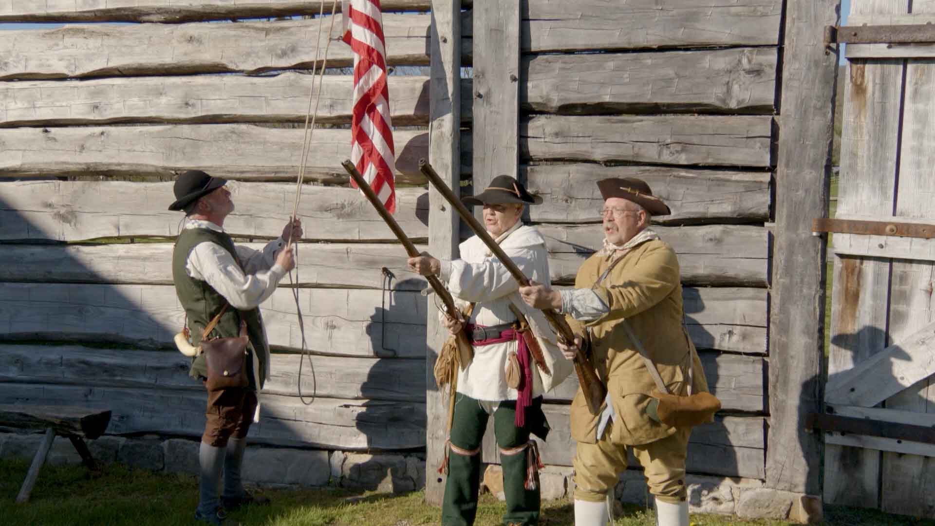 people demonstrating raising the flag at Fort Roberdeau