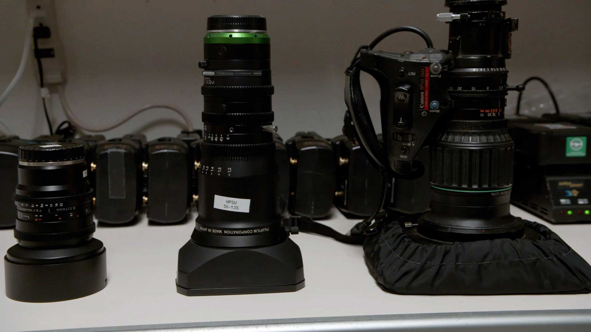 photo of video camera lenses resting on a shelf